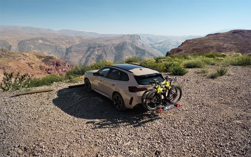 BMW X3 parked along a mountain.  