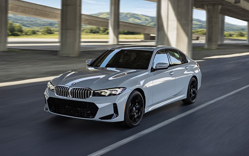 BMW 330i xDrive motion shot driving down the road.