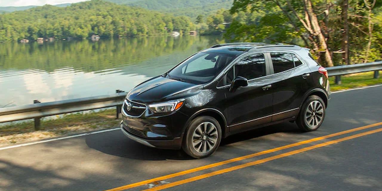Three quarter view of black Encore driving on scenic road