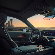Passenger View of the Driver's Side of the 2025 Cadillac LYRIQ Outlooking a City During a Sunset