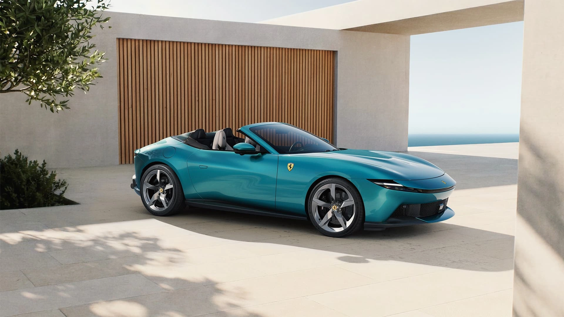 Ferrari Amalfi Spider in teal, three-quarter front view, parked on a coastal terrace