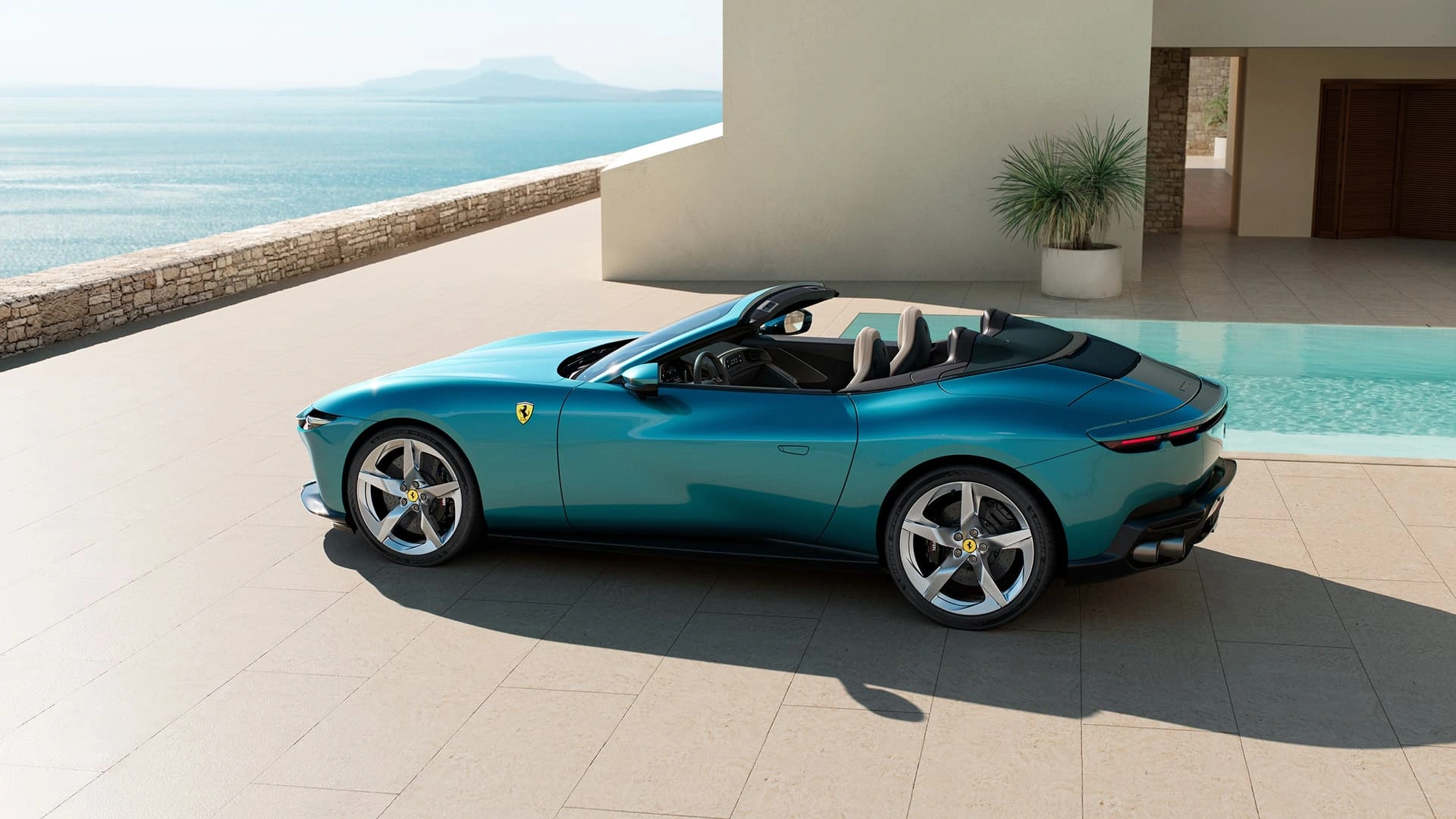 Ferrari Amalfi Spider in teal, elevated side profile view with soft top down, parked beside a pool