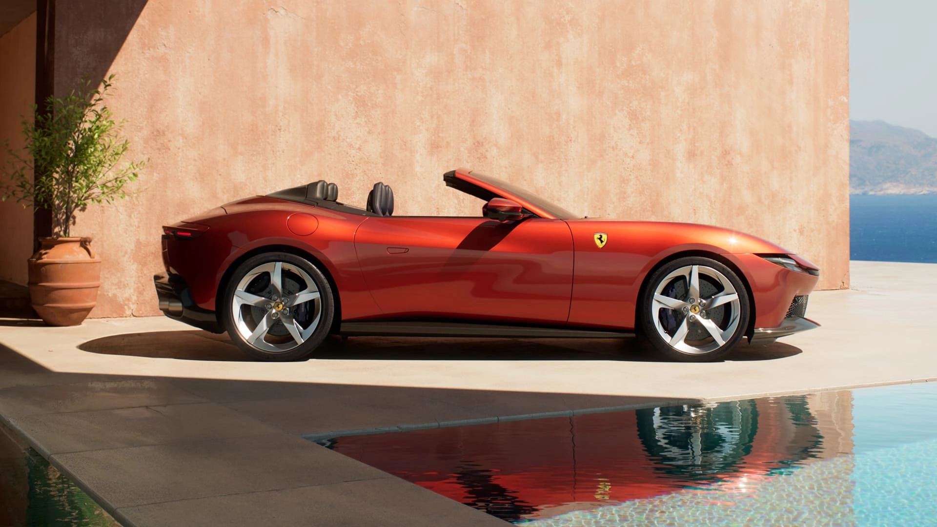 Ferrari Amalfi Spider in red, side profile view with windscreen deleted, parked beside a pool