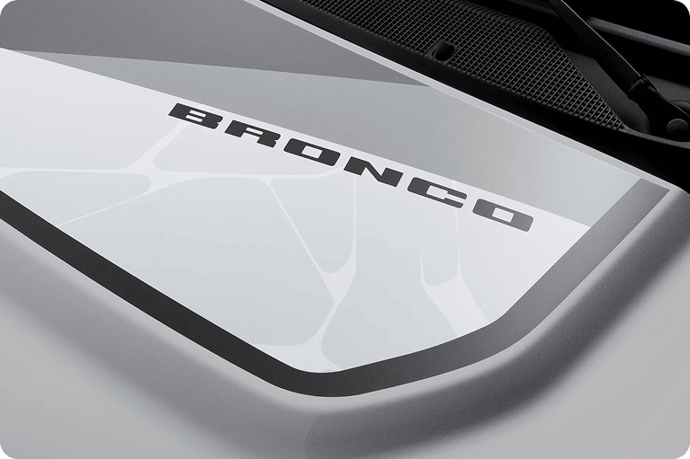 Close-up of a Ford Bronco OBX hood graphic with the Bronco name on a gray and white camouflage-style design.