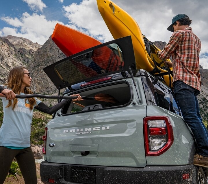 Man fixing kayak on roof of Ford Bronco Sport 