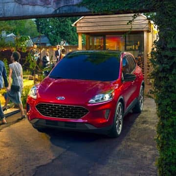 Red Ford Escape parked in front of a house party