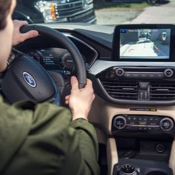 An interior shot of a Ford Escape with rear view camera display
