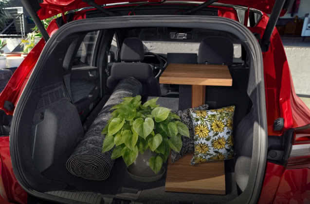 Placing items into a red Ford Escape cargo area.