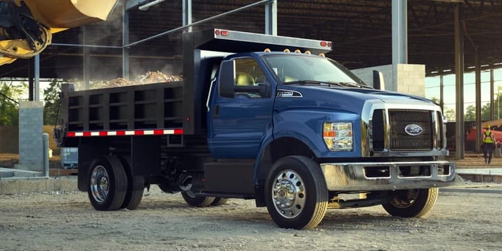 Blue Ford F-750 truck parked in front of a construction site
