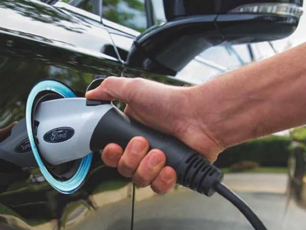 Person's hand plugging in the Ford Fusion Plug-in Hybrid