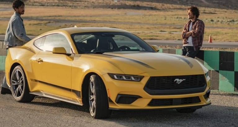 a yellow 2024 Ford Mustang on a ractrack