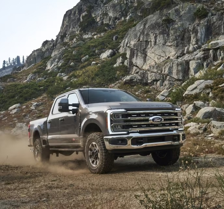 Super Duty driving along quarry-like path with rocks and ridges in background