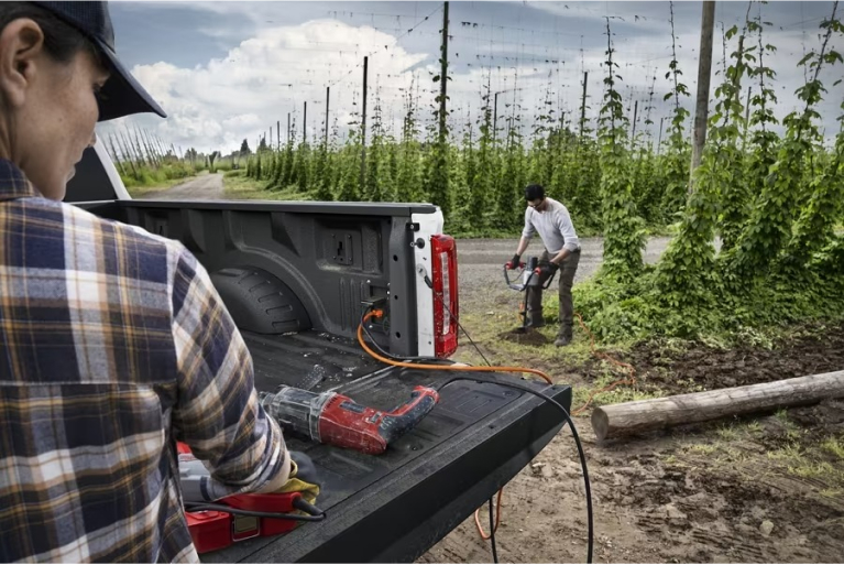 Worker using auger powered by Super Duty from outlet in bed