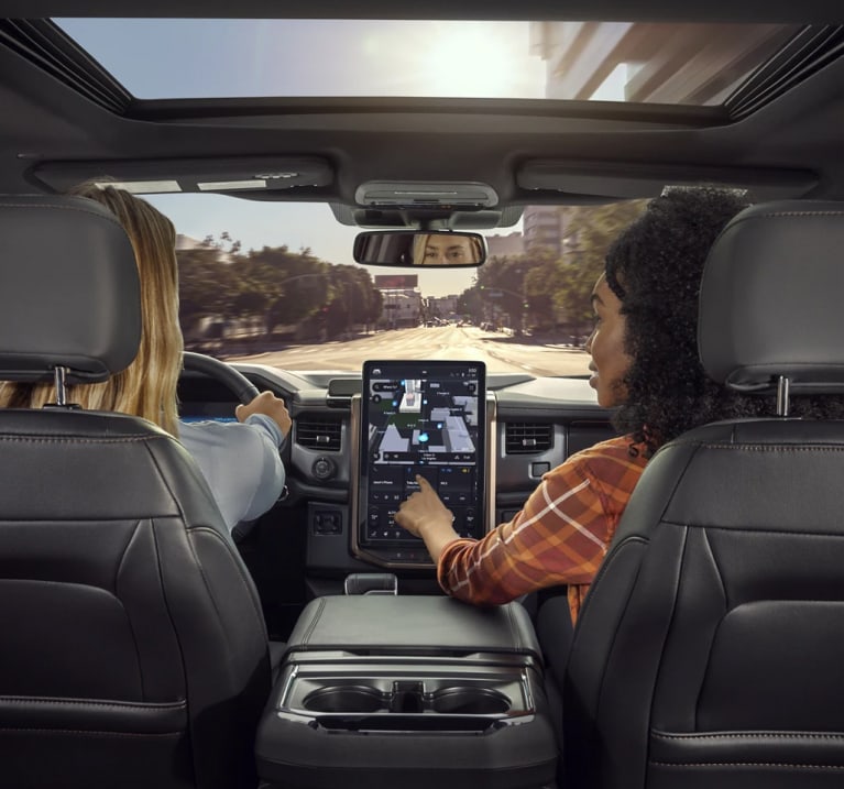 People touching the touch screen on the interior of of Ford F-150 Lightning truck.