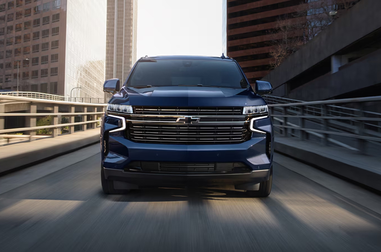 Blue Chevy truck driving on bridge towards camera
