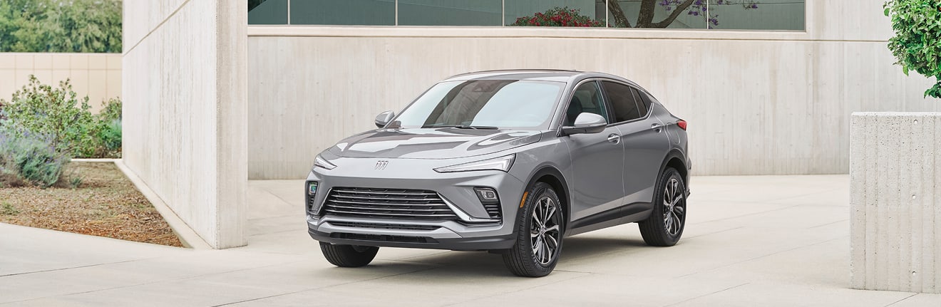 A silver Buick SUV parked outside of a modern garage