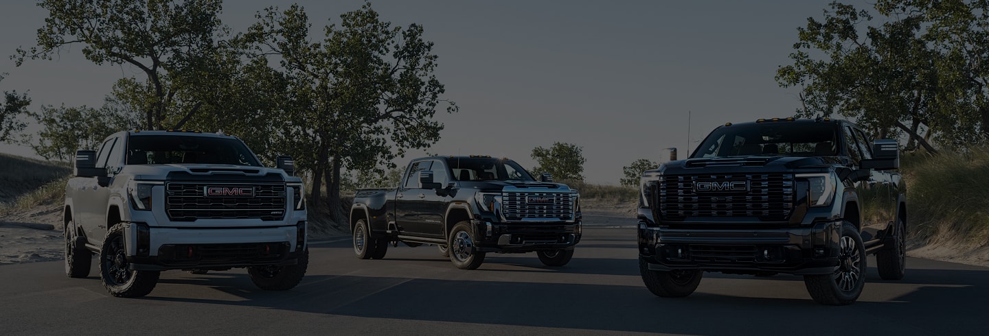 lineup of GMC trucks parked in a field.