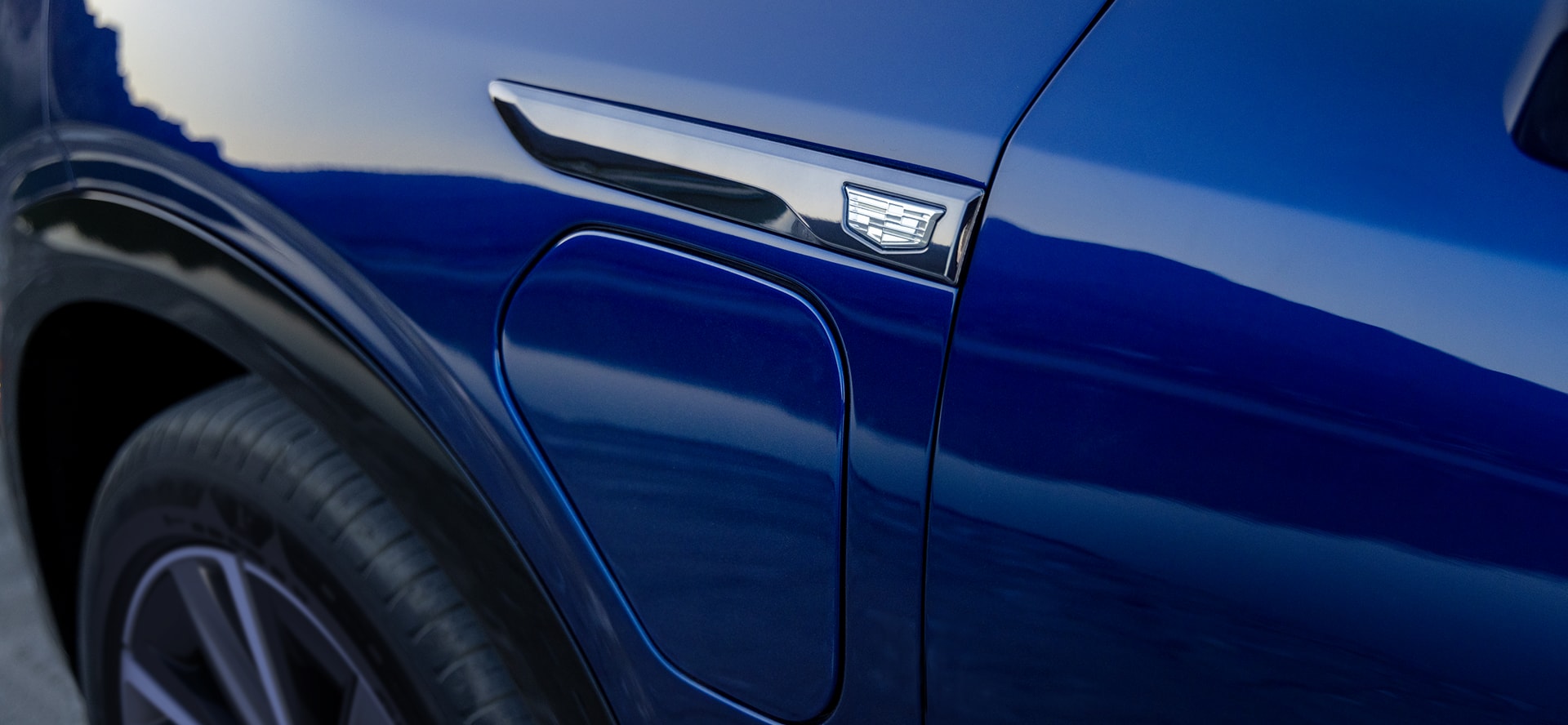Closeup of the charge port cover on a Cadillac Vistiq