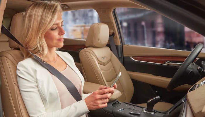 Woman looking at phone inside of car