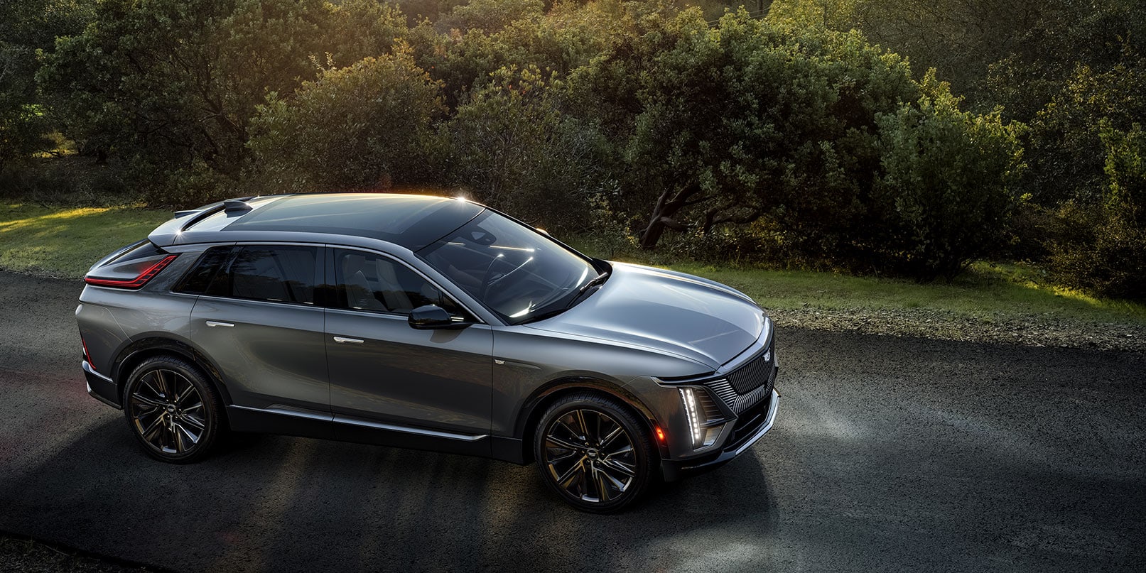 2023 Cadillac Lyriq diving on a tree lined road