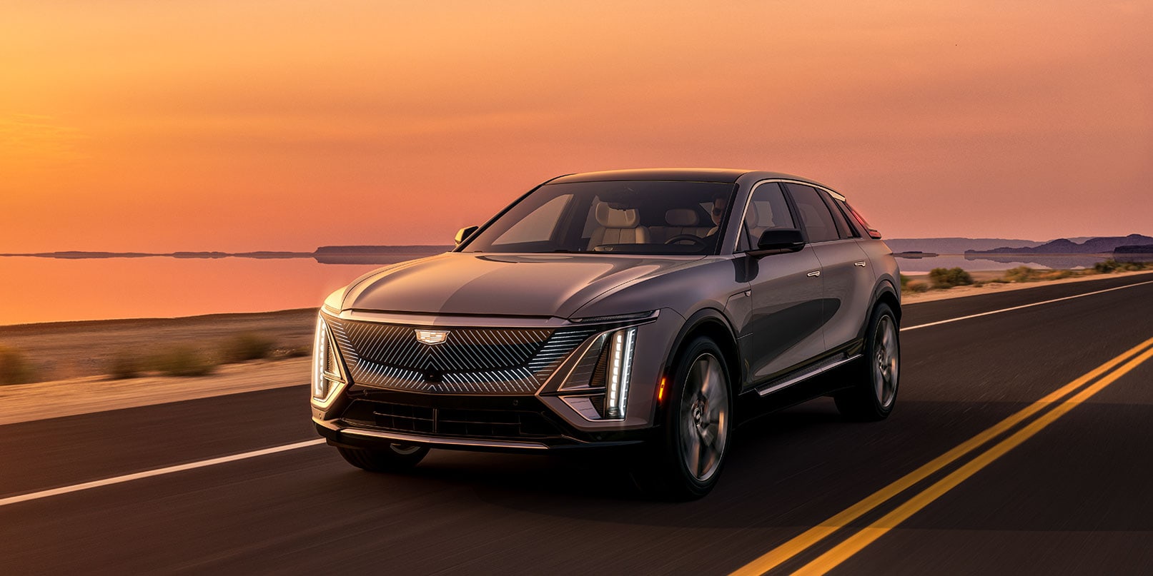 2023 Cadillac Lyriq driving at sunset