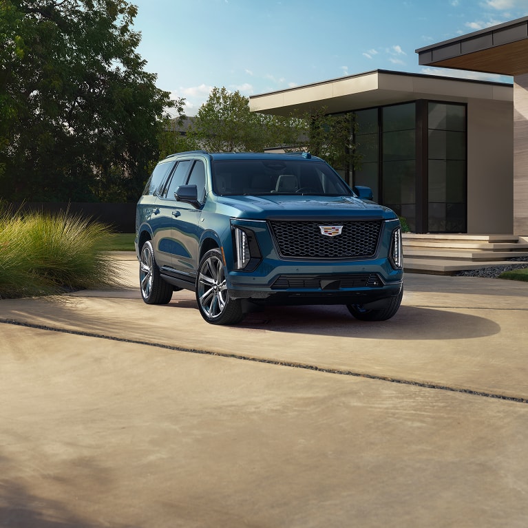 Escalade parked in front of a modern house
