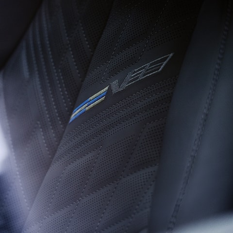 V emblem in upholstery