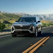 The 2026 Cadillac VISTIQ All-electric SUV Driving Down a Road in the Mountains