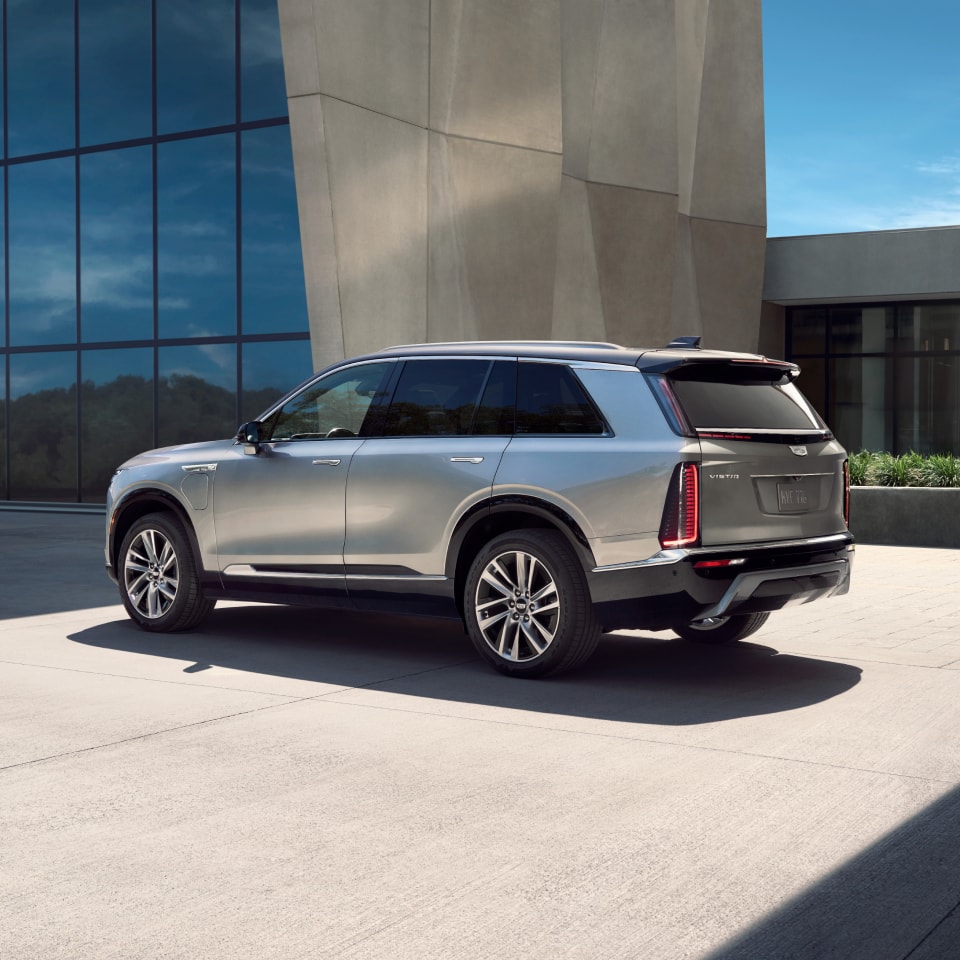 Three-quarters Rear View of the Cadillac VISTIQ Parked Outside of a Modern Building