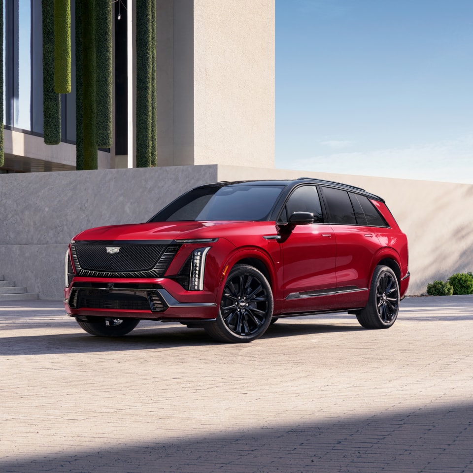 Three-quarters View of a 2027 VISTIQ 3-row Electric SUV Parked near a Concrete Wall