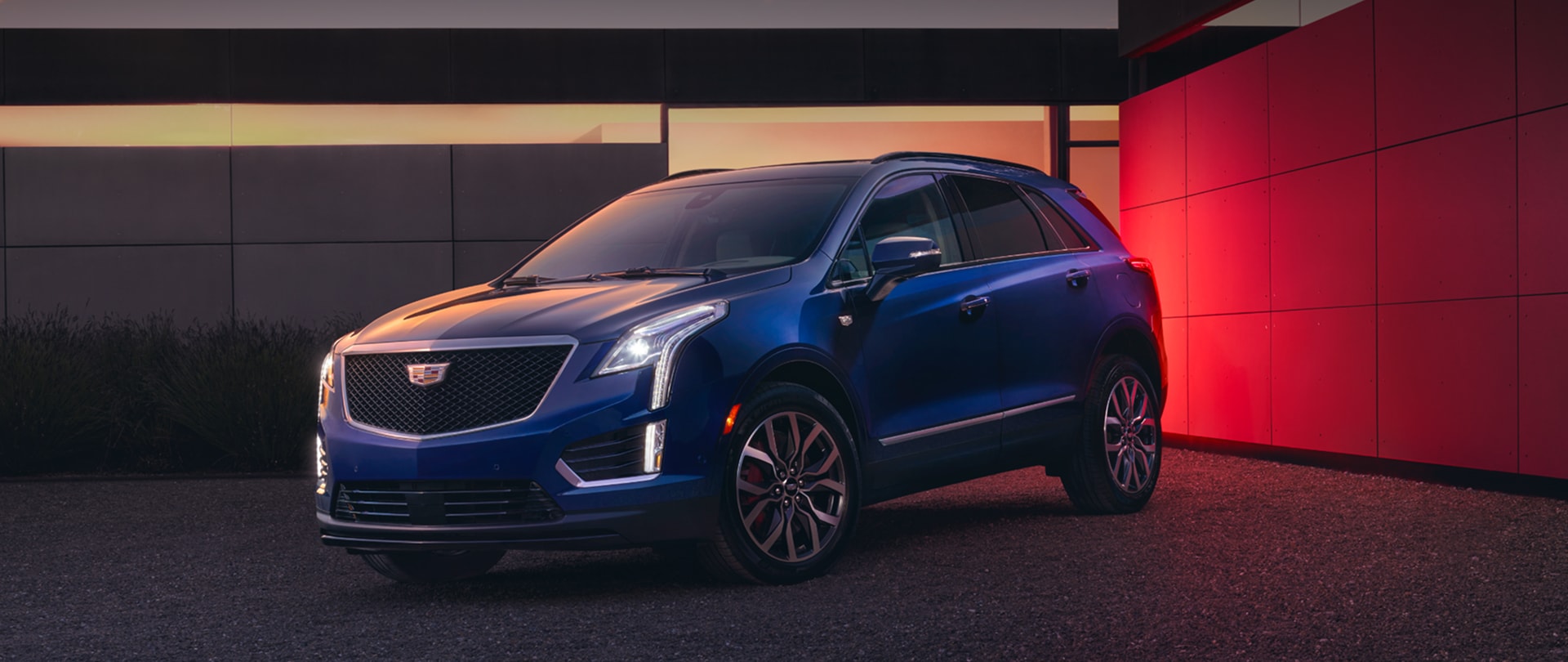 The Beautiful 2026 Cadillac XT5 Parked at Dusk in Front of Modern House With Lights On