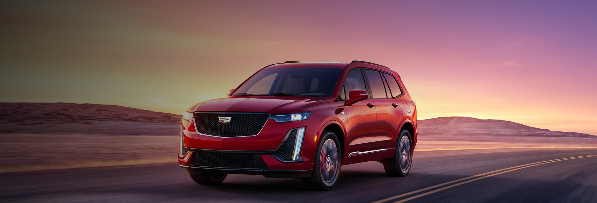 2023 Cadillac XT6 driving at sunset
