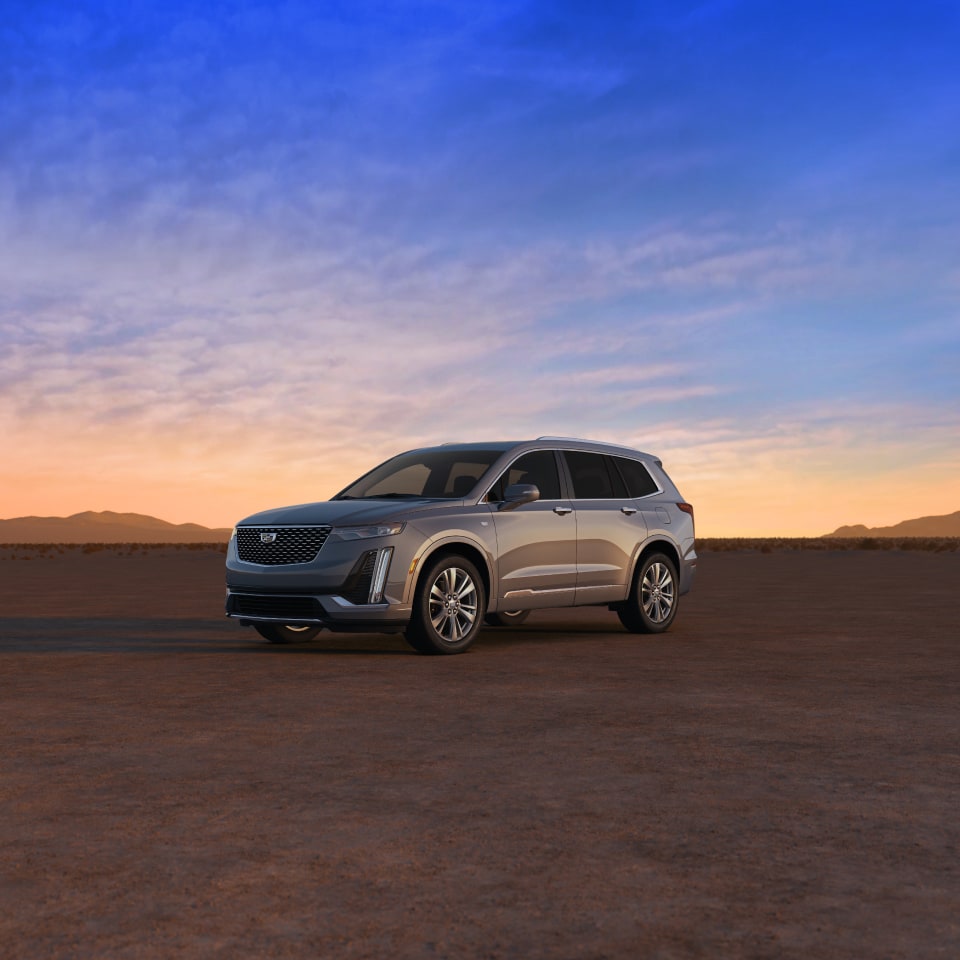Side View of a Silver Cadillac XT6 in a Desert under  an Evening Sky 