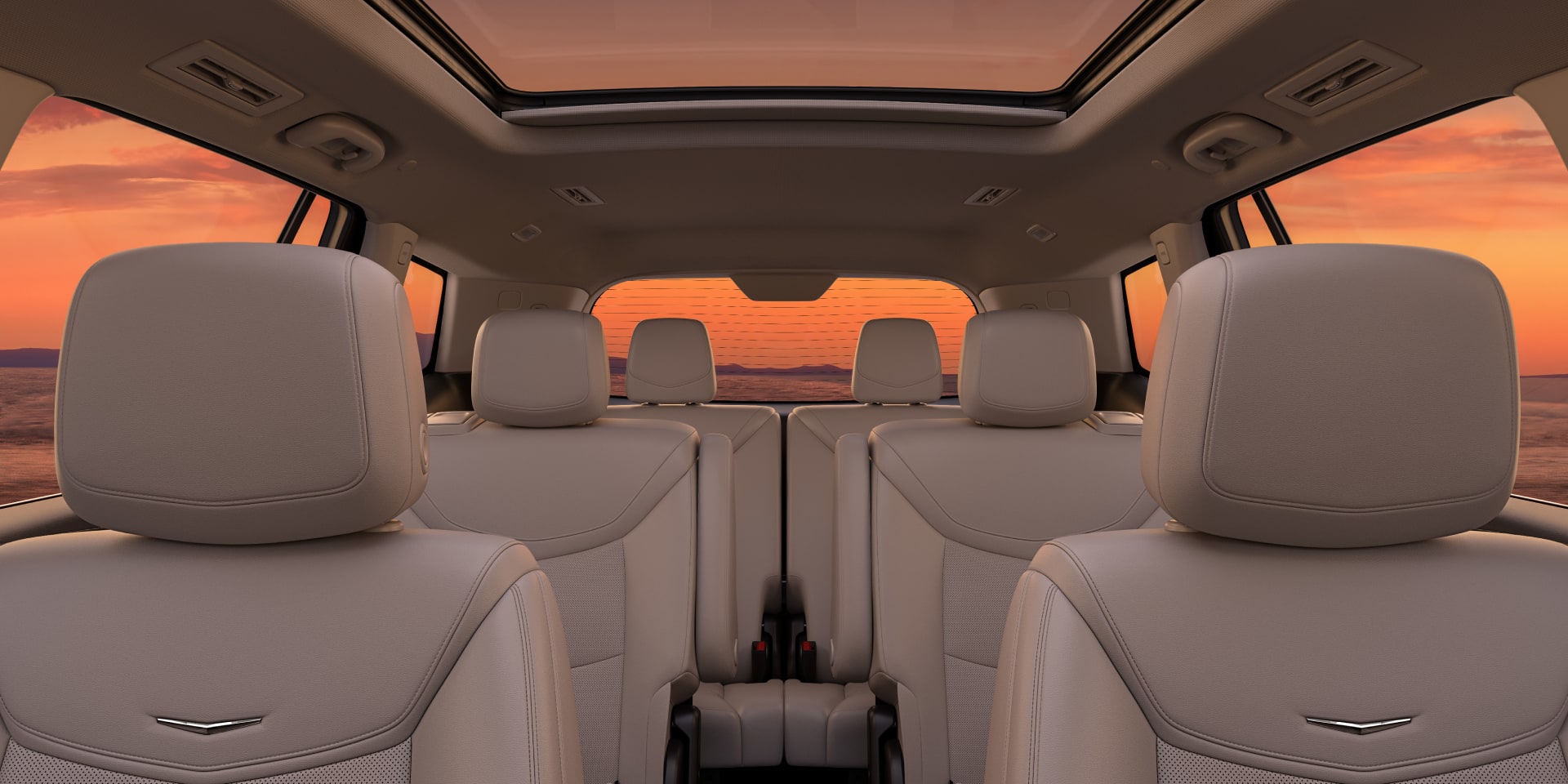 Three Rows of Tan Leather Seats Inside the New  Cadillac XT6 Parked Under the Sunset
