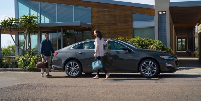 2025 Chevrolet Malibu parked in front of a modern house