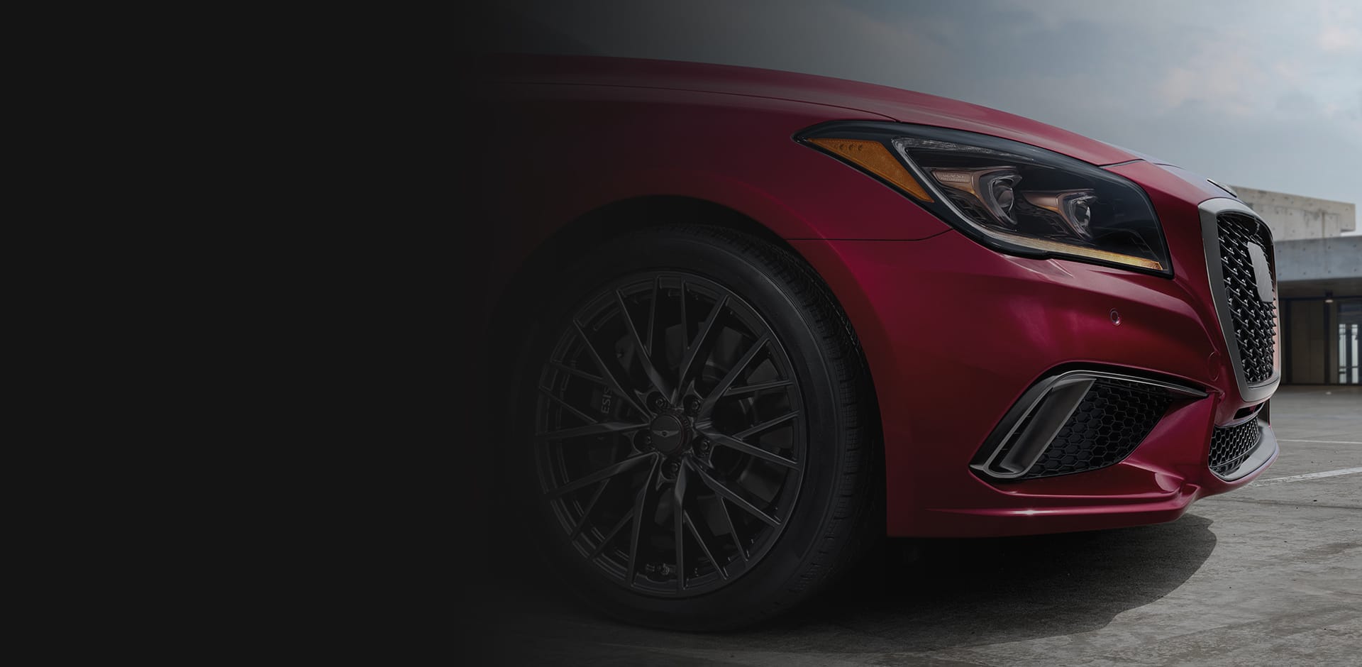 A close-up shot of the front passenger side of a red Genesis