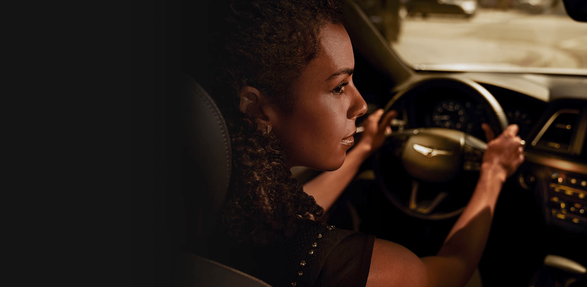 An interior shot of a Genesis vehicle with a woman driving