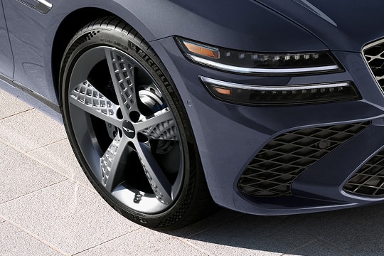 3/4 passenger side close up of wheel details on Genesis G80 in Ceres Blue