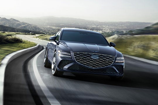 7/8 front passenger view of Genesis G80 in Ceres Blue driving country road with rolling hills