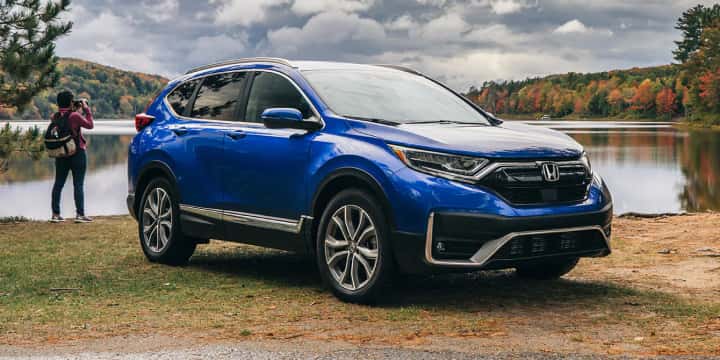 Blue Honda CR-V Hybrid parked in front of lake