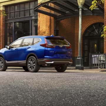 Blue Honda CR-V Hybrid parked in front of building