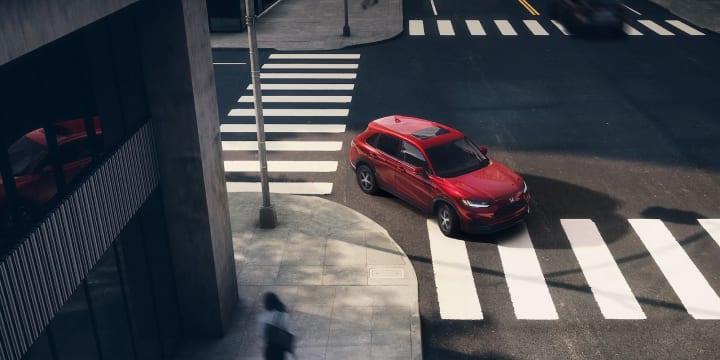 Red 2025 Honda HR-V turning right through a 4 way intersection