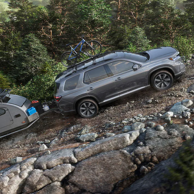 Honda Pilot towing a trailer up a mountain