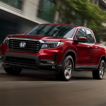 Red Ridgeline driving down road