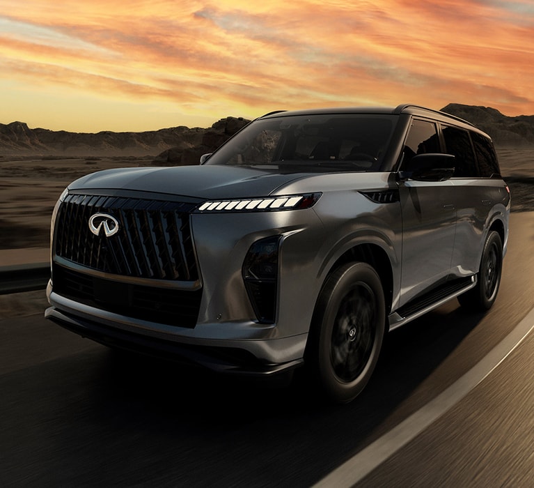 2026 INFINITI QX80 driving at sunset