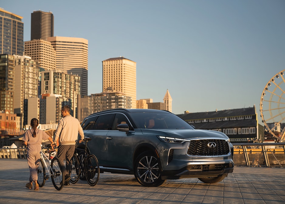 INFINITI SUV parked in front of a city skyline