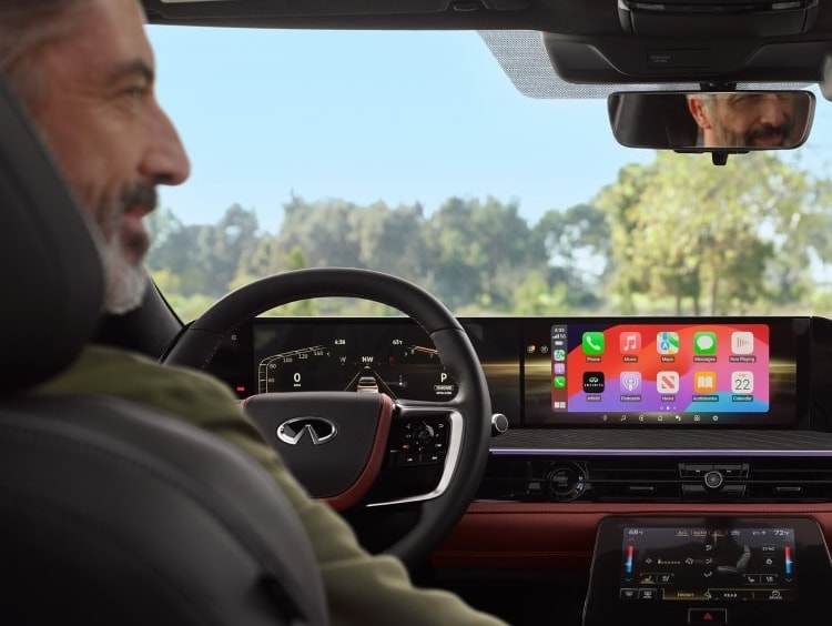 driver behind the wheel of an INFINITI with apple carplay