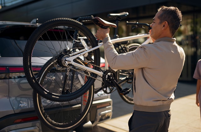 Driver mounting a bike to the back of an INFINITI SUV