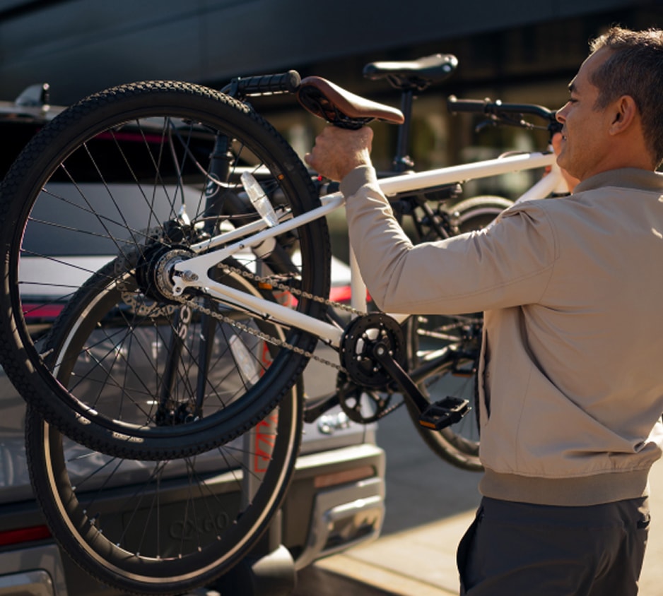 Driver mounting a bike to the back of an INFINITI