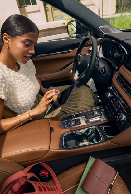 INFINITI Owner using a tablet in the driver's seat
